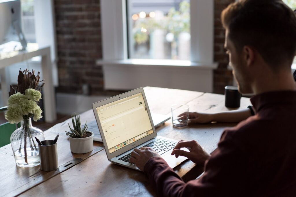 VExpenses man operating laptop on top of table