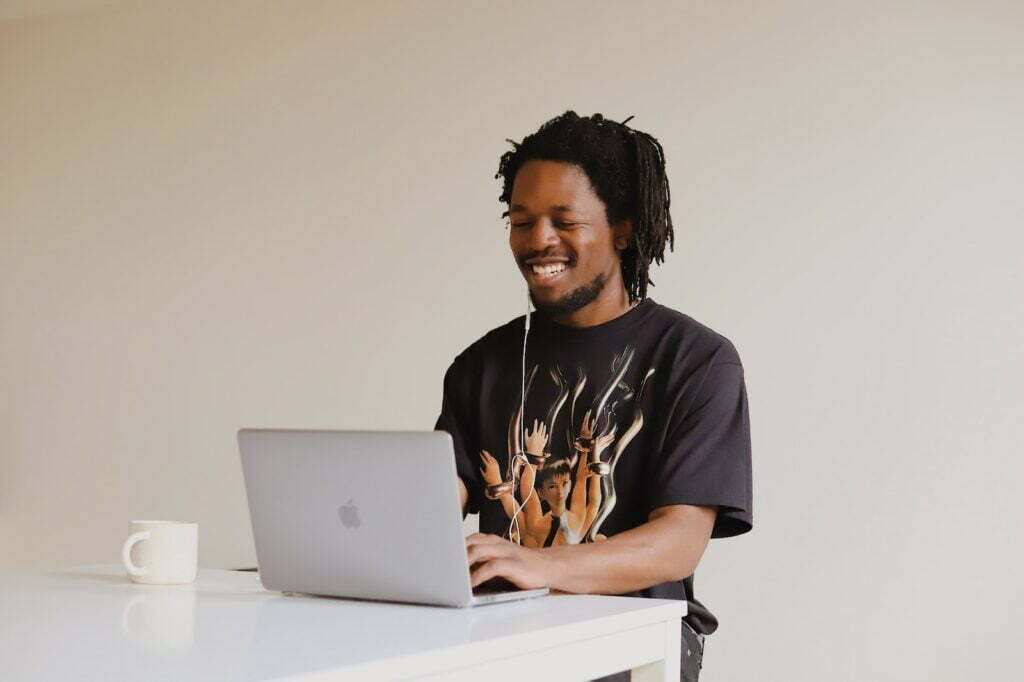 NAVA redix man in black crew neck t-shirt using macbook