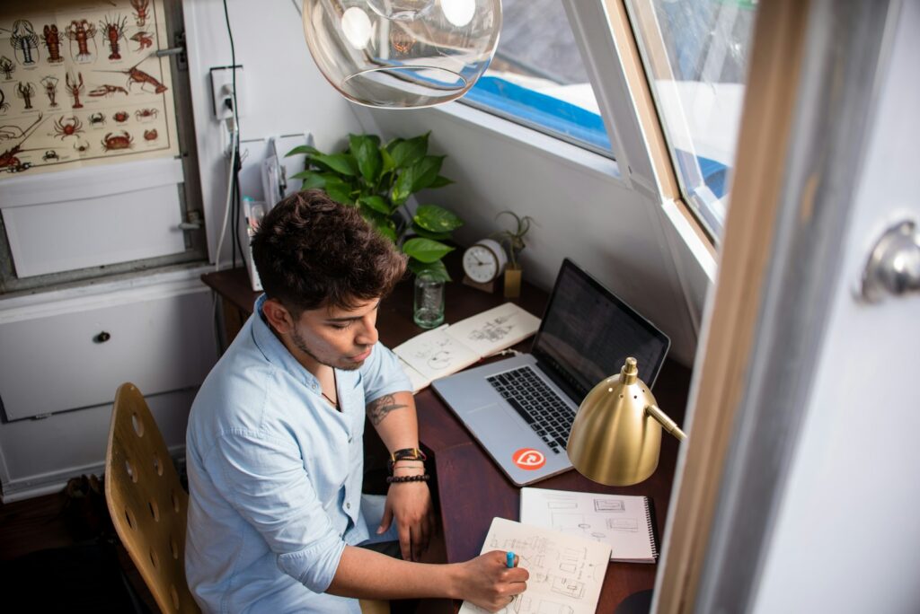 Agente e Assistente Remoto na BairesDev man sits while writing in front of MacBook