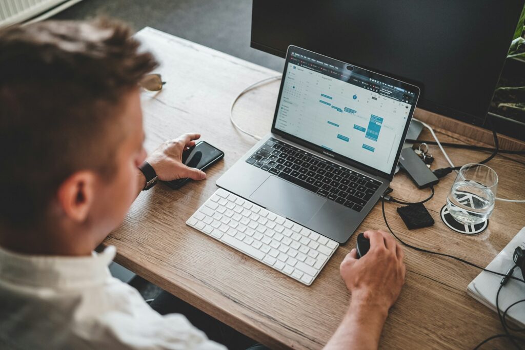 56 Vagas de Emprego na Quality Digital man holding mouse and iPhone while using Macbook Pro
