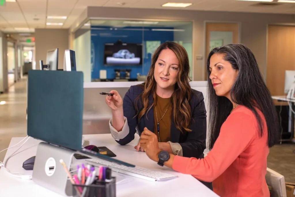 Saga Consulting two women sitting at a table looking at a computer screen