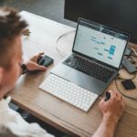 56 Vagas de Emprego na Quality Digital man holding mouse and iPhone while using Macbook Pro